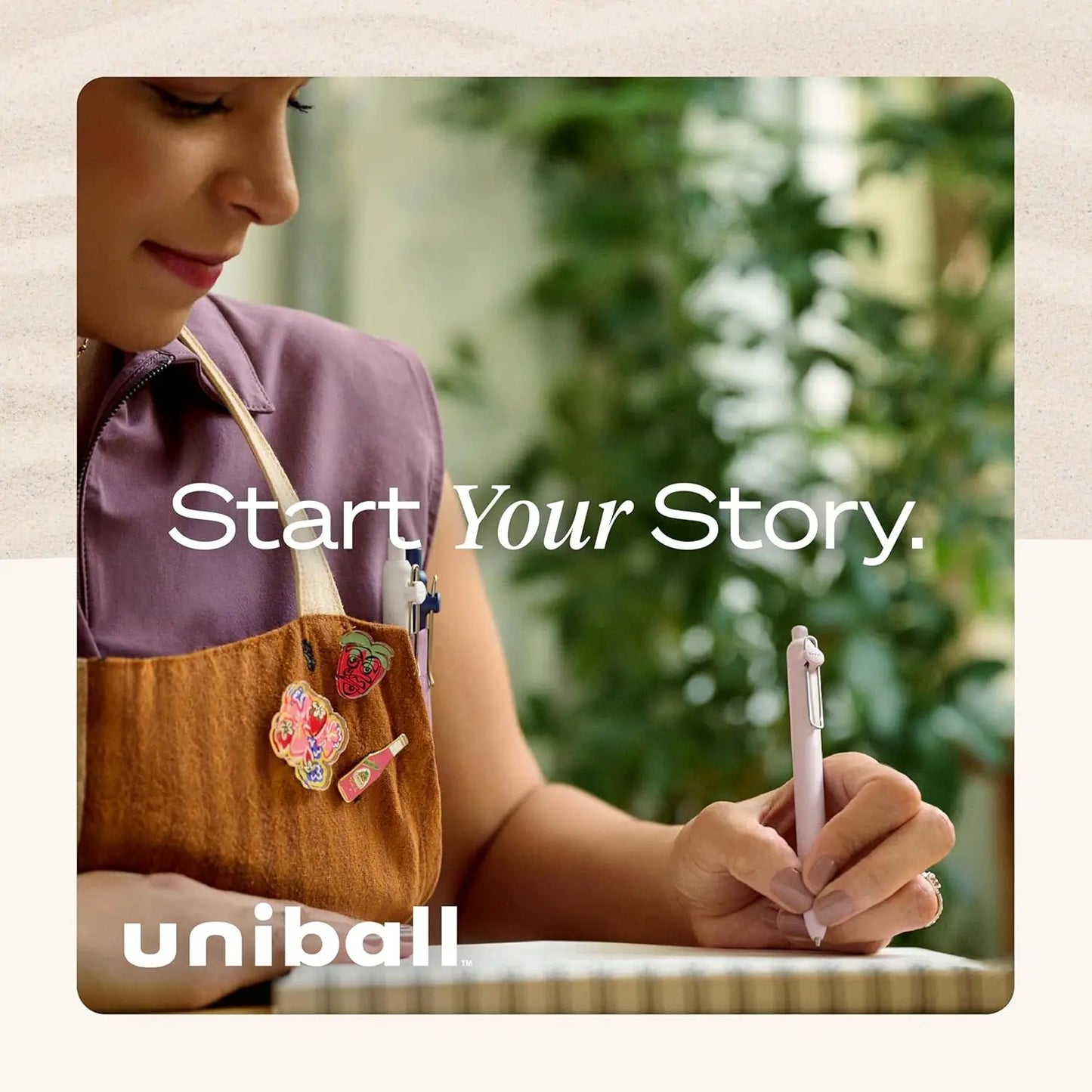 Person holding a pen with 'Start Your Story' text and Uniball logo.