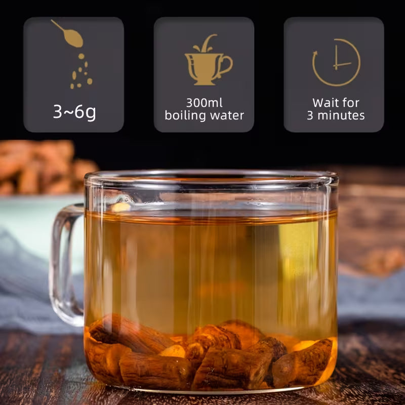 Glass mug with tea and tea bags on a wooden surface, with instructions for making tea displayed above.