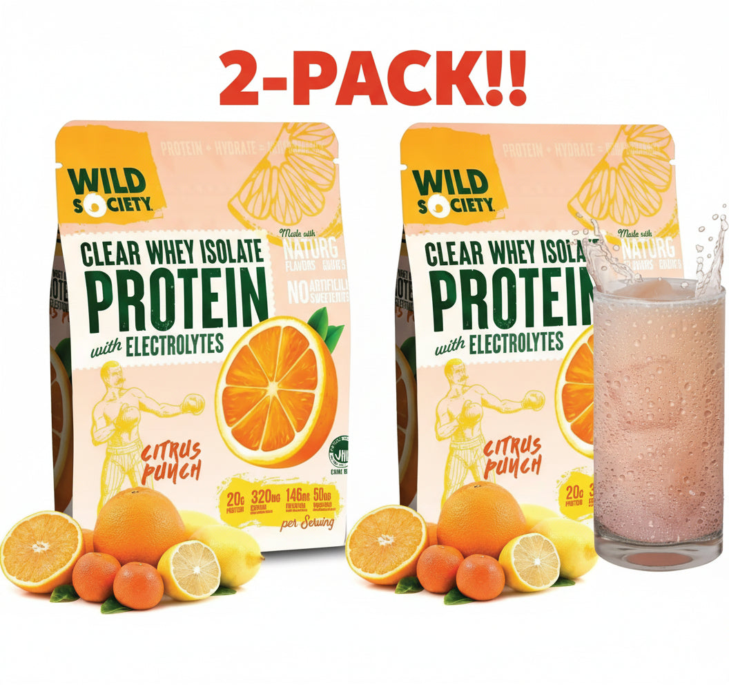 Two packages of Wild Society protein powder with citrus punch flavor, surrounded by oranges and lemons, and a glass of the protein shake.