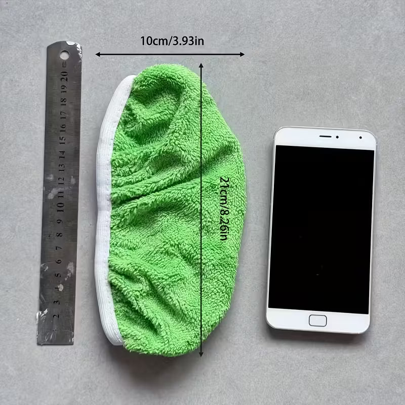 Green cleaning pad with measurements next to a smartphone on a gray background