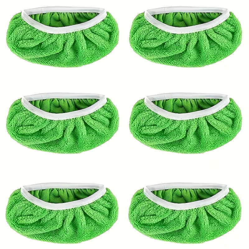 Six green shoe covers with white bands on a white background