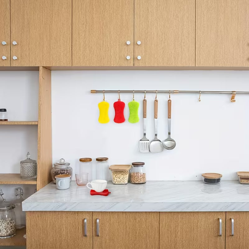 Modern kitchen with wooden cabinets, marble countertop, and hanging utensils.