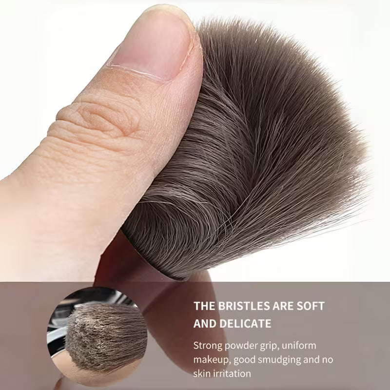 Makeup brush with soft bristles held by a finger, showing close-up of bristles and text about brush properties.