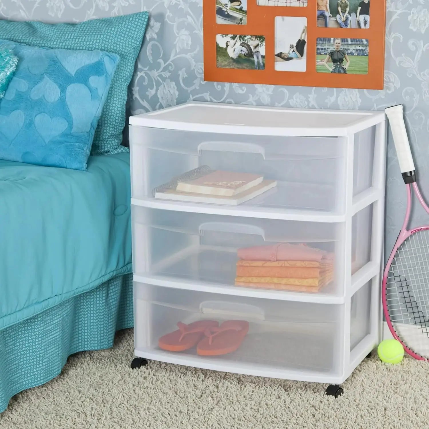 Clear plastic storage drawers with wheels in a bedroom setting.