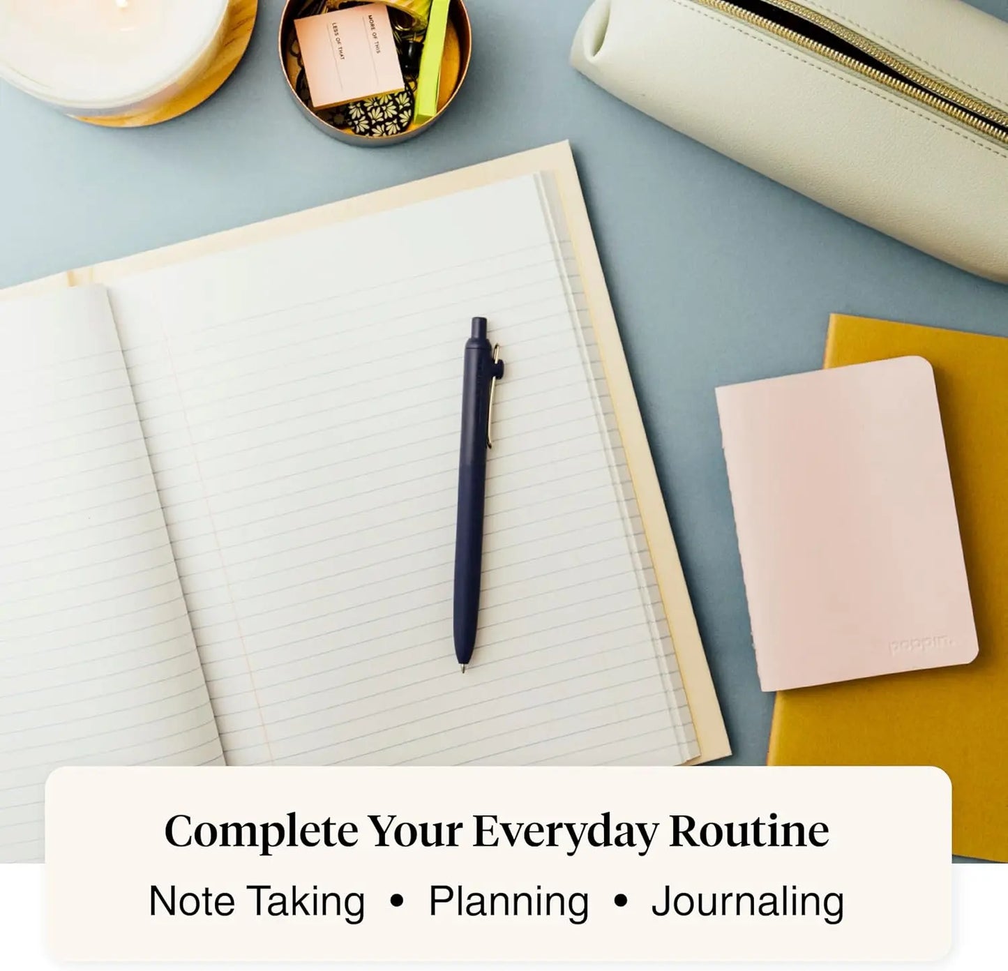 Notebook with pen, small notebook, and pouch on a light blue surface.