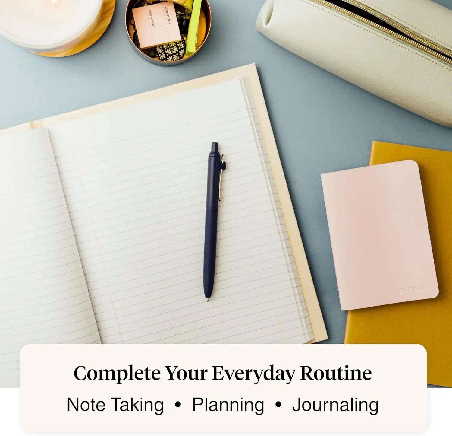 Notebook with pen, small notebook, and pouch on a light blue surface.