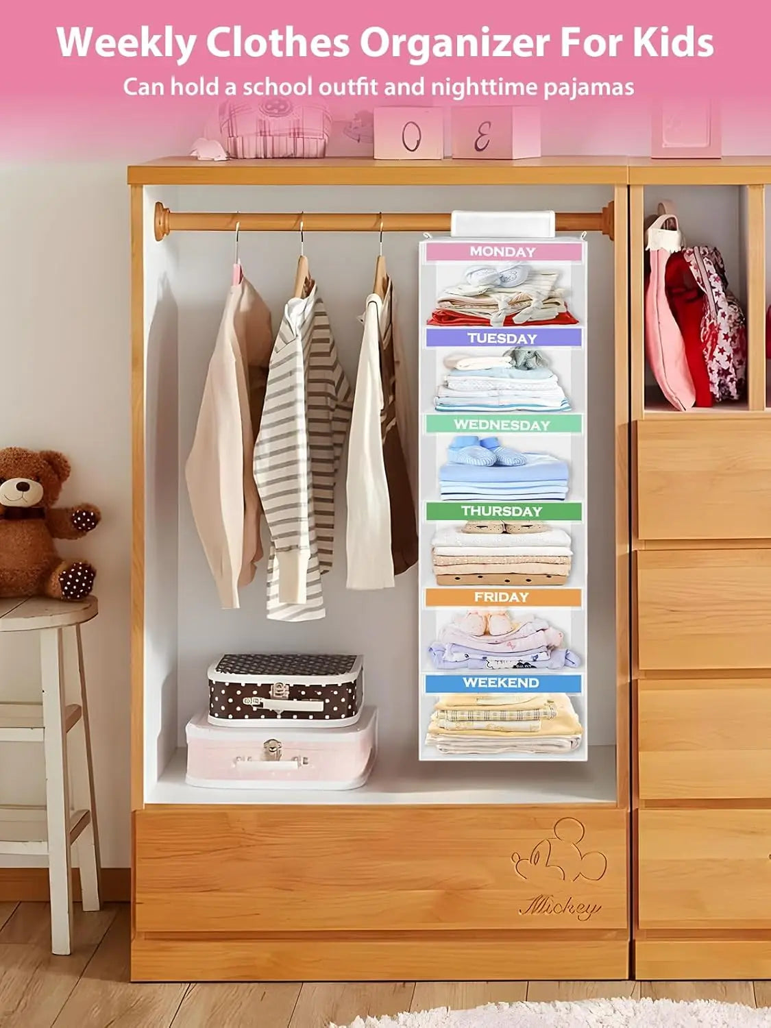 Weekly clothes organizer for kids with hanging clothes and labeled days of the week on a wooden wardrobe.