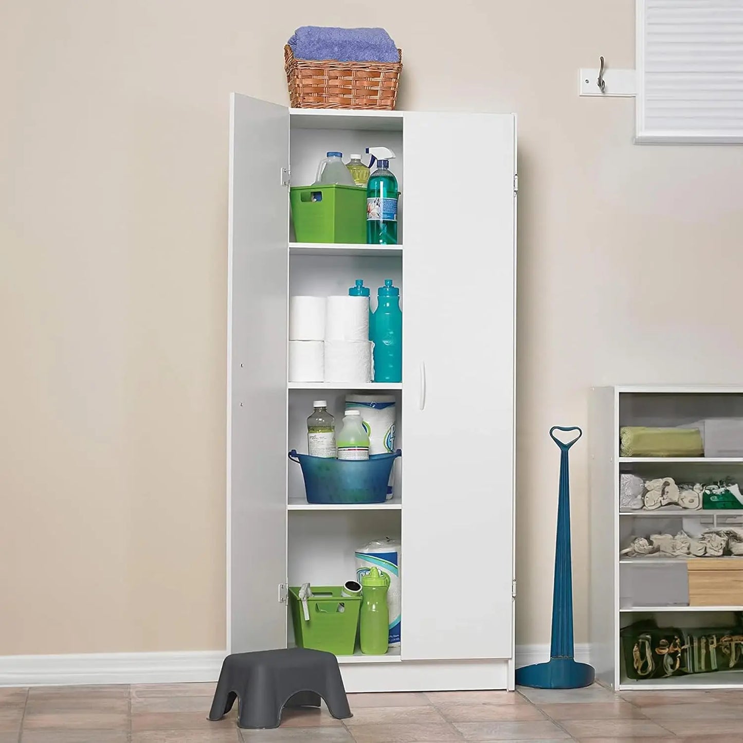 White storage cabinet with various items inside, next to a beige wall.
