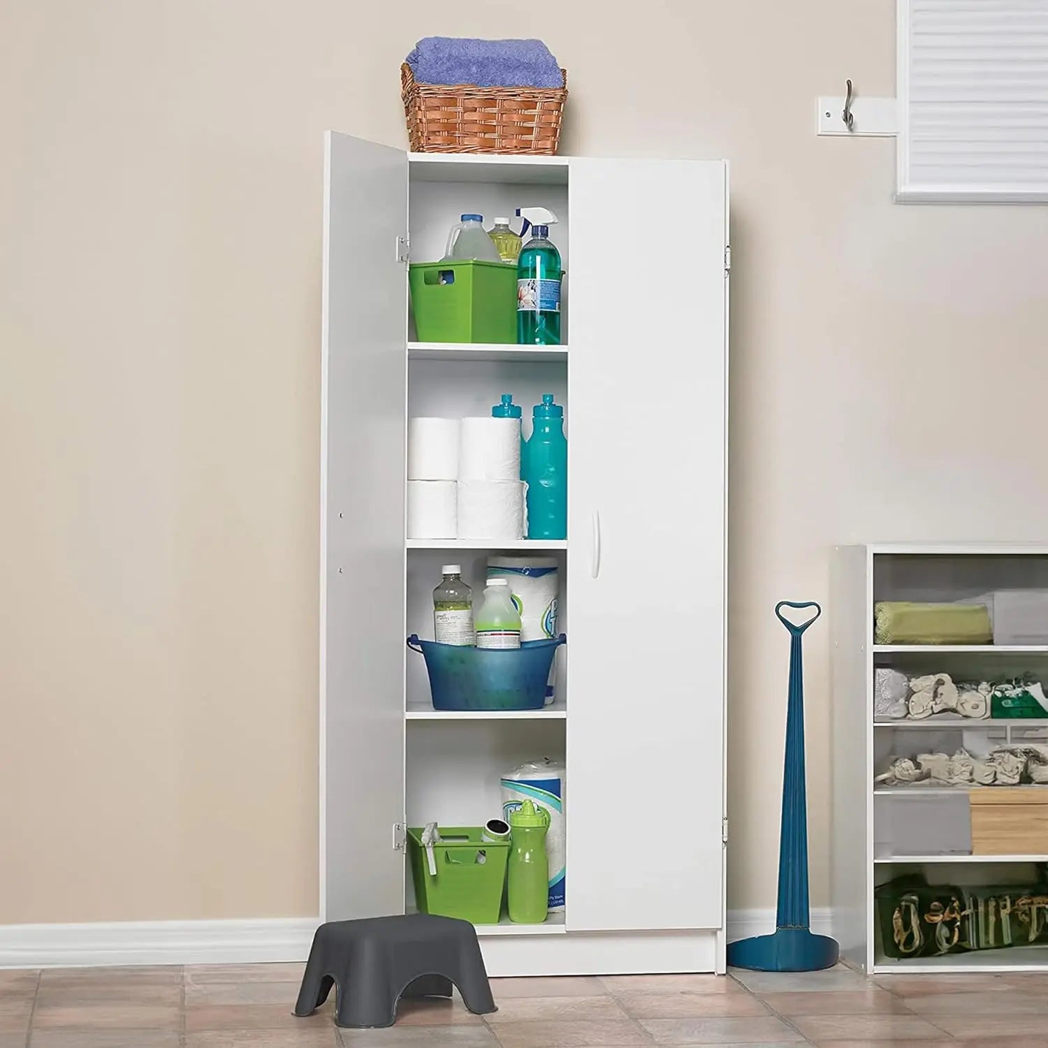 White storage cabinet with various items inside, next to a beige wall.