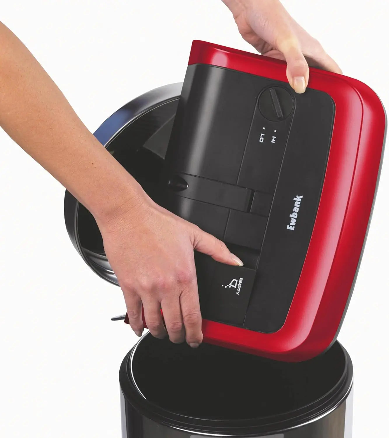 Red and black vacuum cleaner being used on a white background