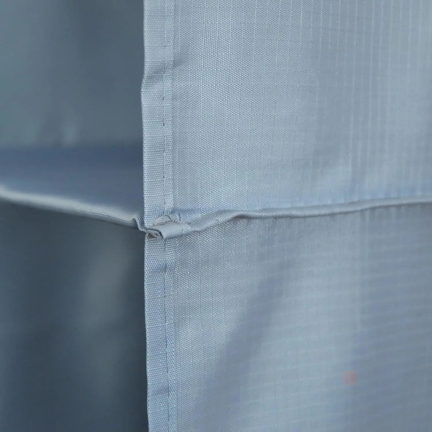 Close-up of a light blue fabric with a subtle pattern on a plain background