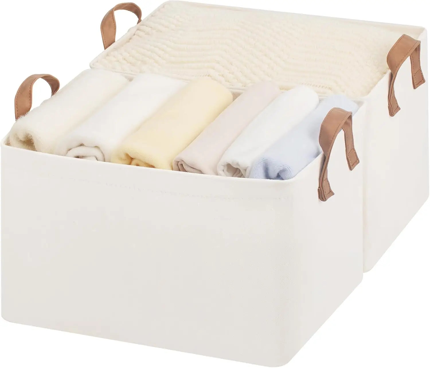 Beige fabric storage basket with handles containing folded clothes on a white background