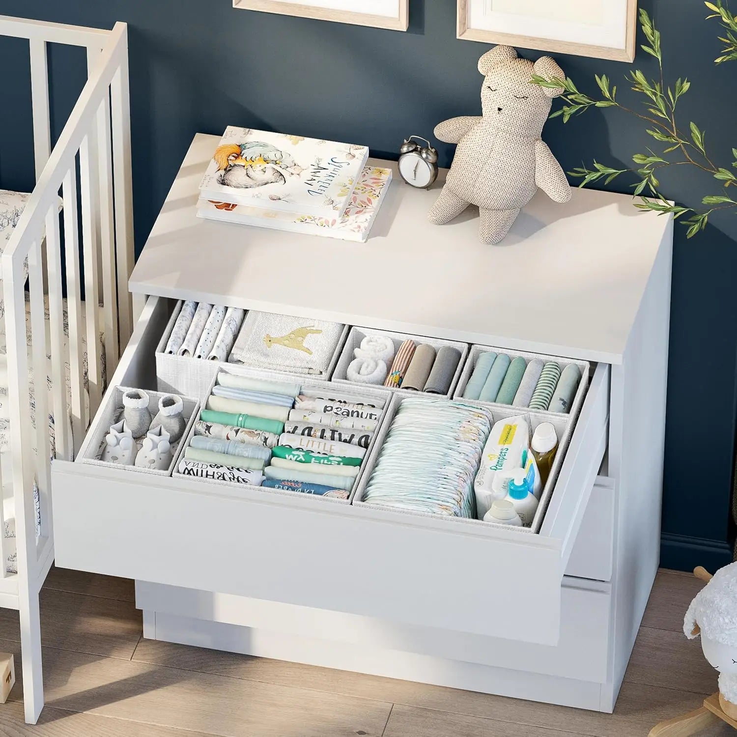 White dresser with open drawer containing baby supplies in a nursery setting.