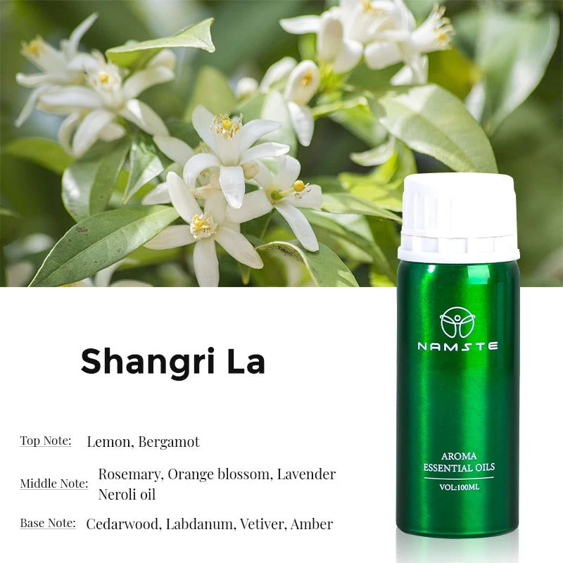 Green essential oil bottle with white cap labeled 'Namste' next to a plant with white flowers.