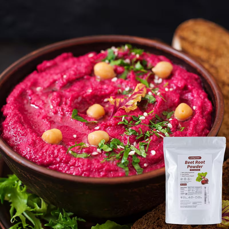 Bowl of pink hummus with chickpeas and herbs, next to a package of beet root powder.
