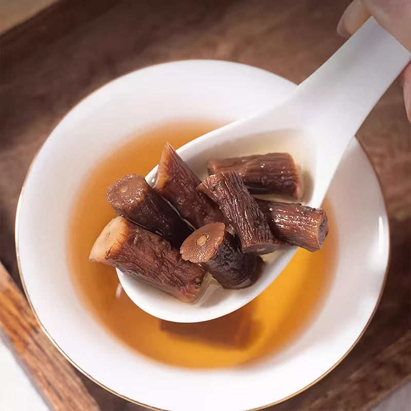 White spoon with dried plums浸泡在一杯茶中