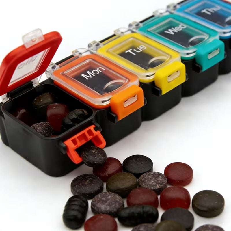 Colorful pill organizer with compartments labeled Monday to Sunday, containing various pills on a white background.